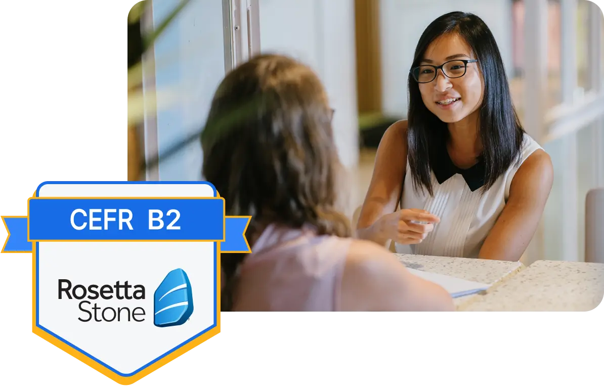 Two girls talking next to a Rosetta Stone certificate badge image.